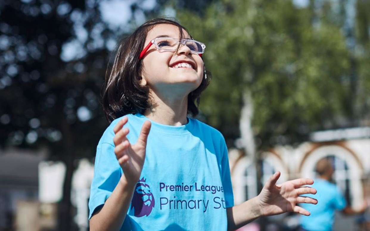 Girl in Premier League Primary Stars t-shirt looking excitedly to the sky