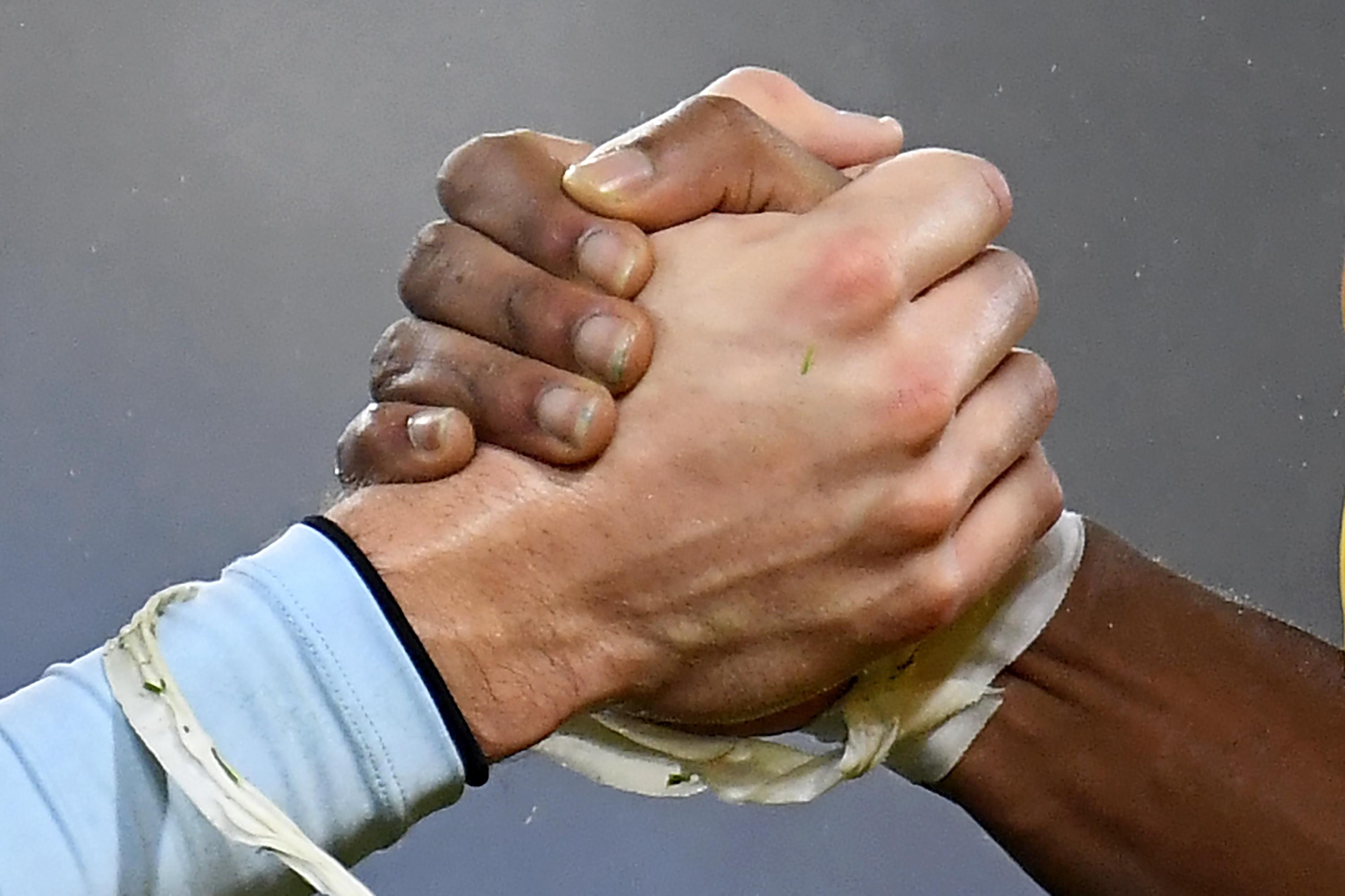 Premier League footballers hold hands.